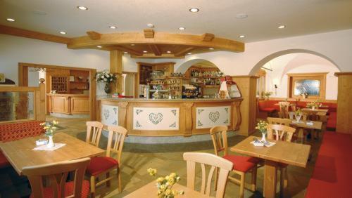 ein Restaurant mit Tischen und Stühlen und eine Küche in der Unterkunft Hotel Italia in Baselga di Pinè