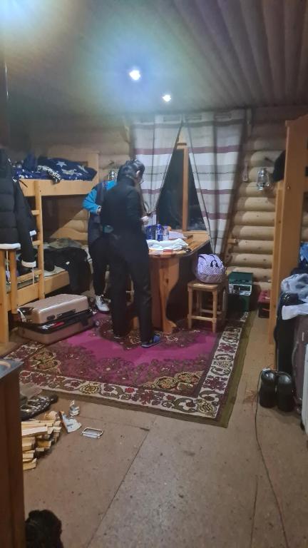 two people standing in a room with a table at Таежный домик Васильево in Poperechnoye
