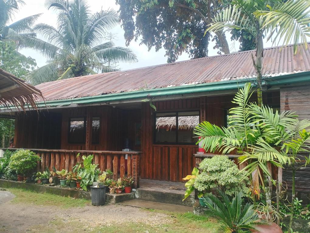 a wooden house with plants in front of it at Naramalan Inn in San Vicente