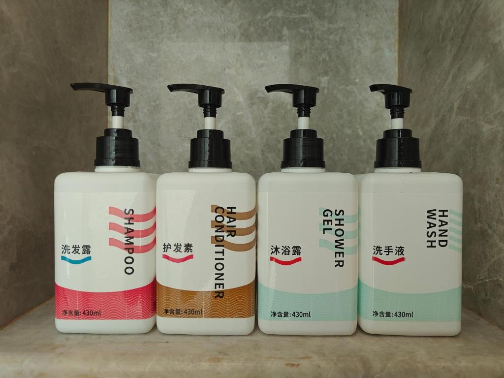 a group of four shampoo bottles sitting on a counter at 宜尚酒店 日月广场骑楼老街店 in Haikou