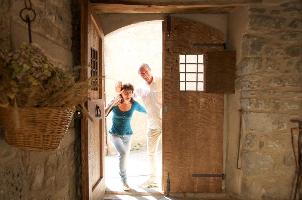 Un homme et une femme sortent d'une porte dans l'établissement Corte della Maddalena, à Busana
