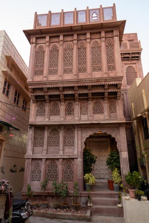 a pink building with a gate and a door at Aakash Heritage Haveli in Jodhpur