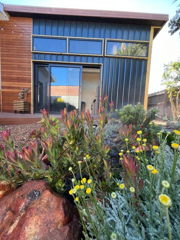 una casa con un giardino con fiori di fronte di Lighthouse Beach cottage a Città del Capo