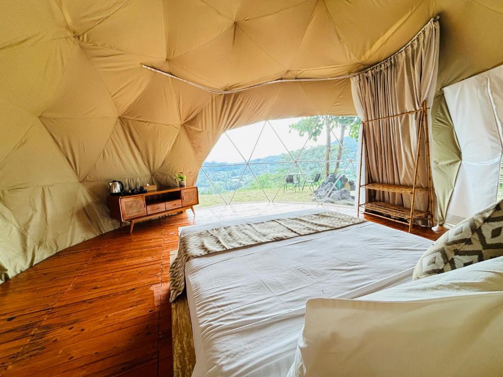 a bedroom with a large bed in a tent at De'Ra Hills Camp Kintamani in Kintamani