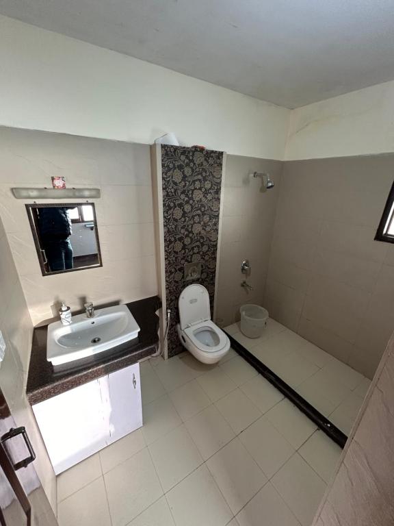 un baño con inodoro y lavabo en Woodfins Stay, en Mussoorie