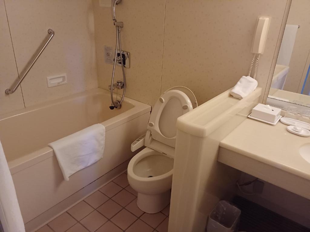 a bathroom with a toilet and a tub and a sink at ANA Crowne Plaza Hotel Kyoto by IHG in Kyoto