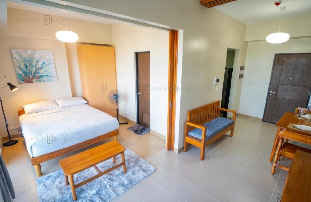 a bedroom with a bed and a desk and a chair at The Palladium Megaworld in Iloilo City