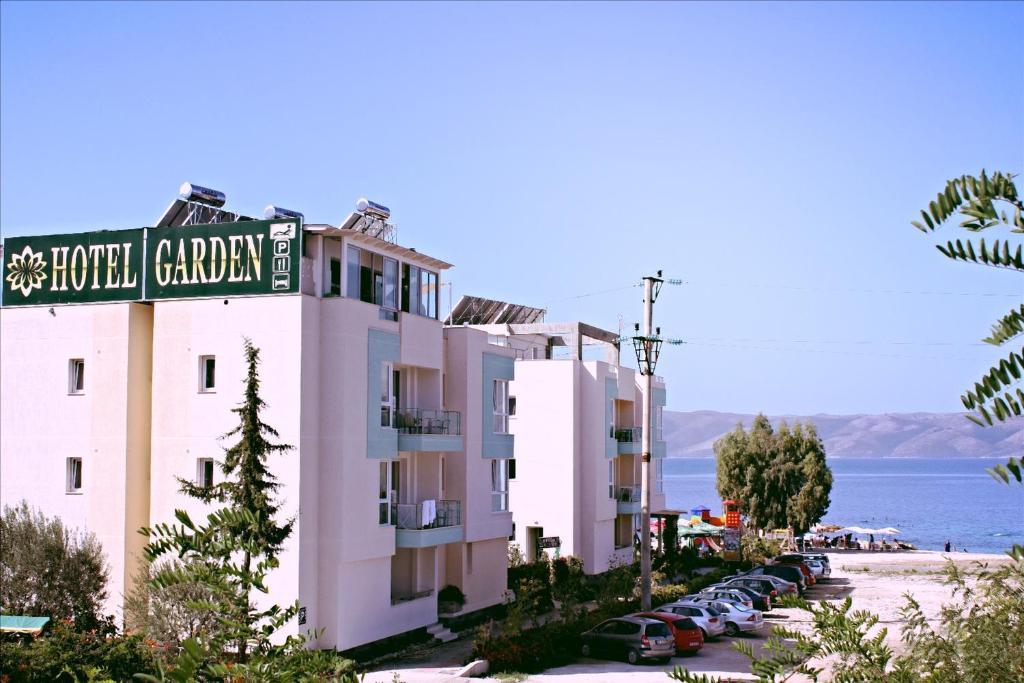 a building with a street sign next to a parking lot at Hotel Garden in Vlorë