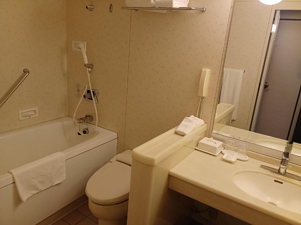 a bathroom with a toilet and a sink and a mirror at ANA Crowne Plaza Hotel Kyoto by IHG in Kyoto