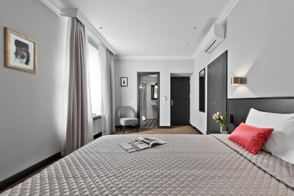 - une chambre avec un grand lit et un oreiller rouge dans l'établissement 15th Avenue, à Vilnius