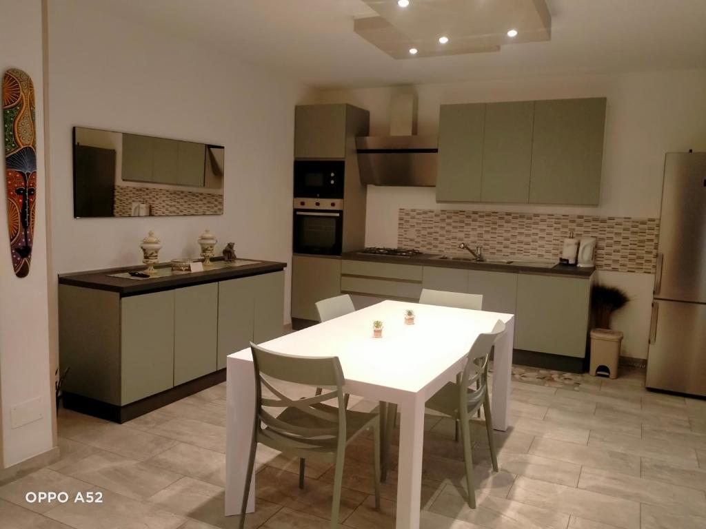a kitchen with a white table and chairs in it at Perla di mare in Montesilvano