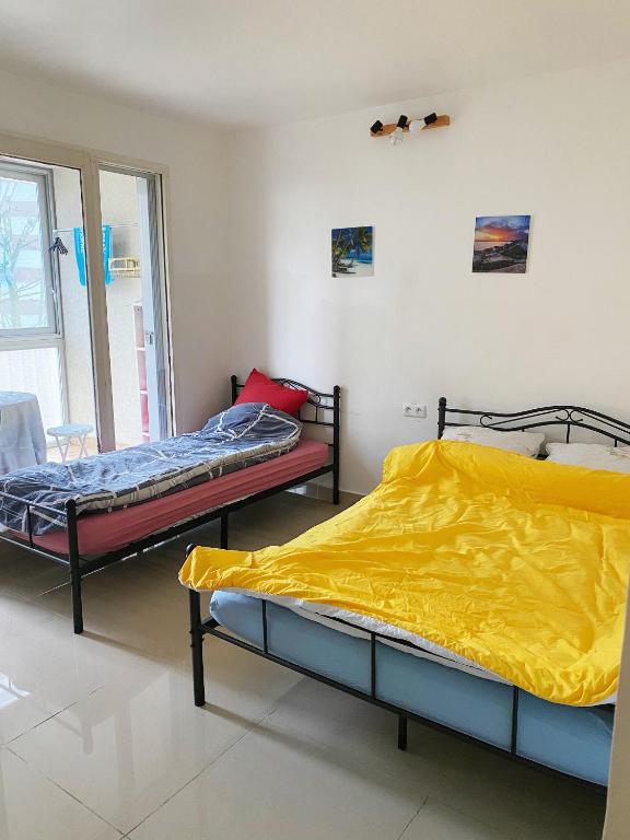 deux lits dans une chambre avec des draps jaunes dans l'établissement YLt333, à Créteil