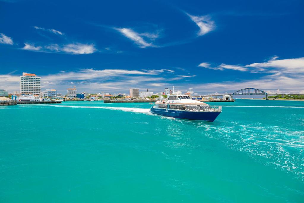 فندق إيست تشاينا سي في جزيرة إيشيغاكي: قارب في الماء مع مدينة في الخلفية