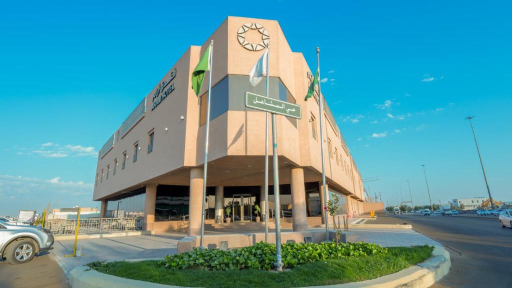 a building with a clock on the side of a street at Aram Hotel - AlMeshael Exit 18 in Riyadh