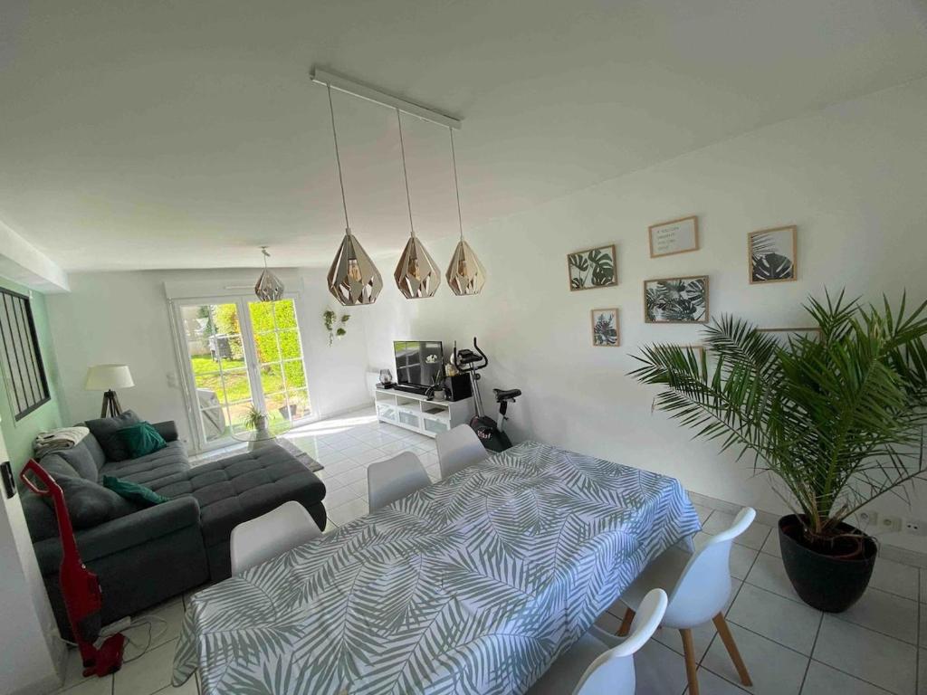 - un salon avec un canapé et une table à manger dans l'établissement Maison de 100m2 avec jardin aux portes de Caen, à Hubert-Folie