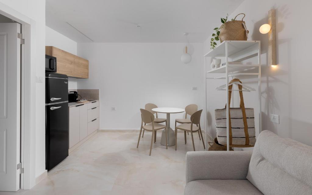 eine Küche und ein Wohnzimmer mit einem Tisch und einer Couch in der Unterkunft אורה דירות אירוח -נץ 9- דירות נופש איכותיות לנופש שקט ואקסלוסיבי in Eilat