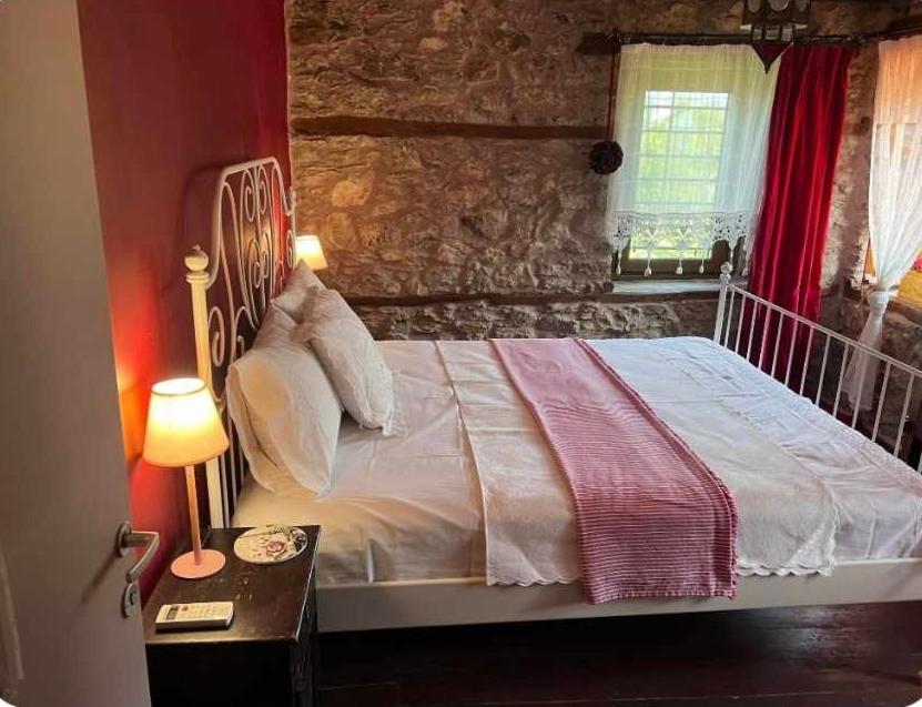 a bedroom with a large bed with a stone wall at Luxury suites in Villa Anasia, Olympia in Skotina