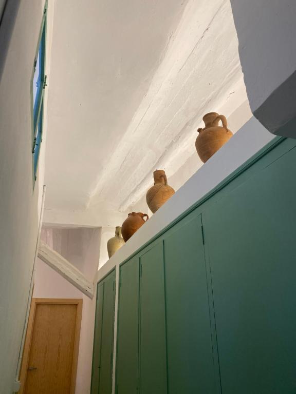 a row of pots sitting on top of a green cabinet at Apartamento El Tozal in Teruel