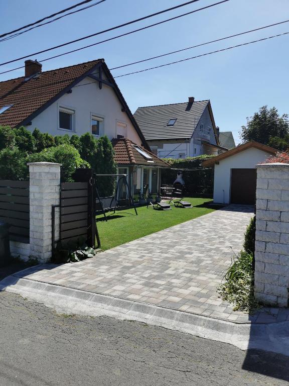 a driveway in front of a white house at Platán Ház Révfülöp in Révfülöp