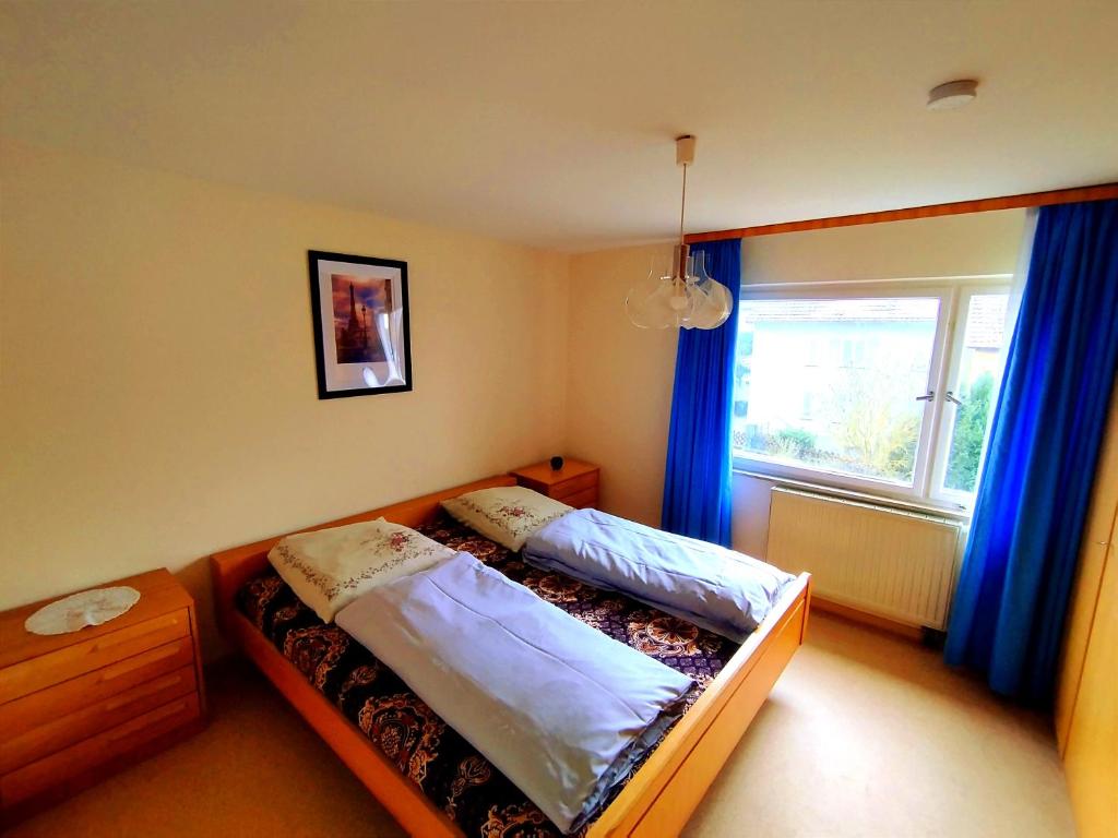 a bedroom with two beds and a window with blue curtains at Charming Apartment near Nature and Mercedes in Sindelfingen