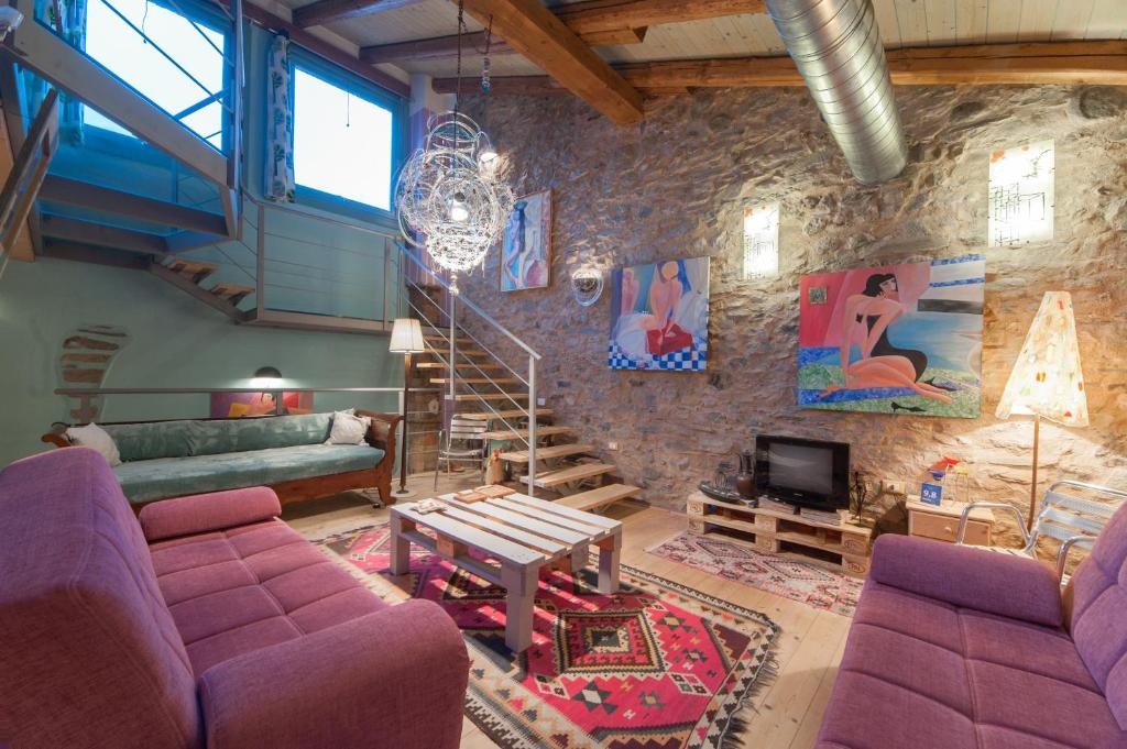 a living room with purple furniture and a stone wall at I Due Loft in Ceto