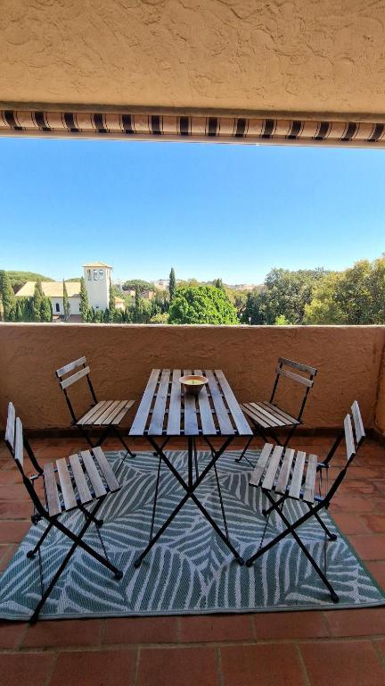 - une table de pique-nique et des chaises sur la terrasse dans l'établissement Studio paisible belle vue et proche de la mer, à Cavalaire-sur-Mer