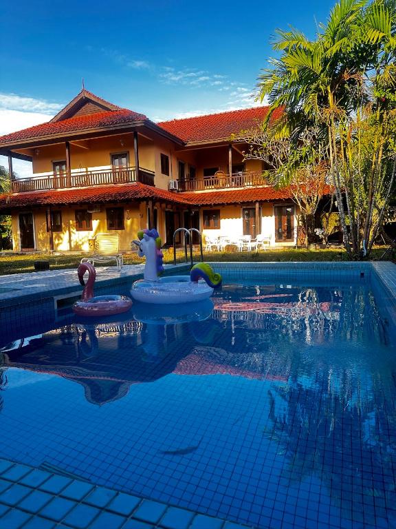 a swimming pool in front of a house at Tropical Pool Villa Langkawi in Pantai Cenang