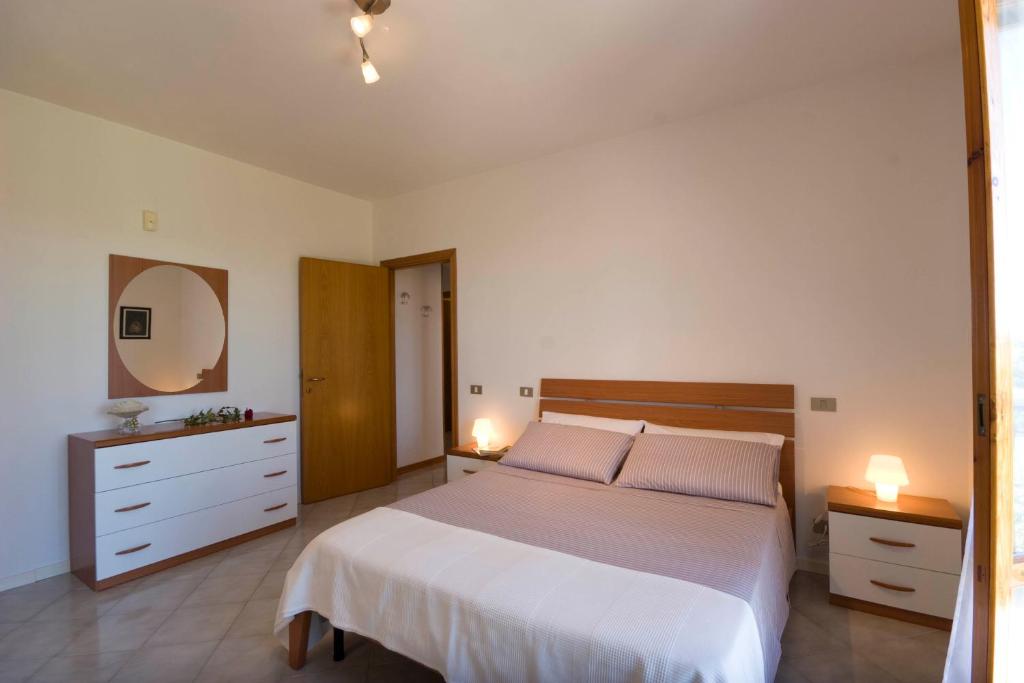 um quarto com uma cama grande e duas mesas de cabeceira em Abbadia 14 em Osimo