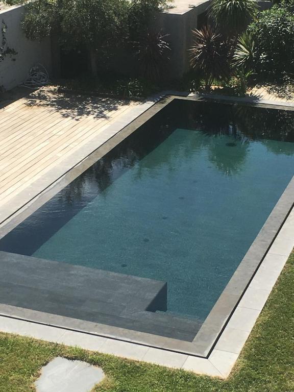 - une piscine dans une cour avec une terrasse en bois dans l'établissement House with pool, à Marseille