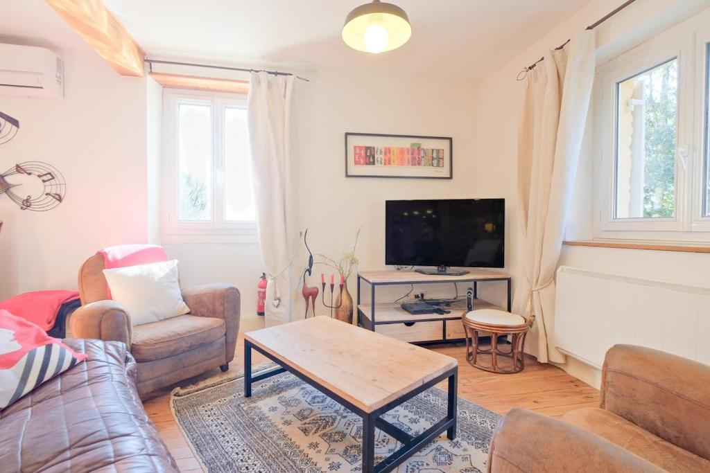 un salon avec un canapé et une télévision dans l'établissement La Renardière, à Proissans