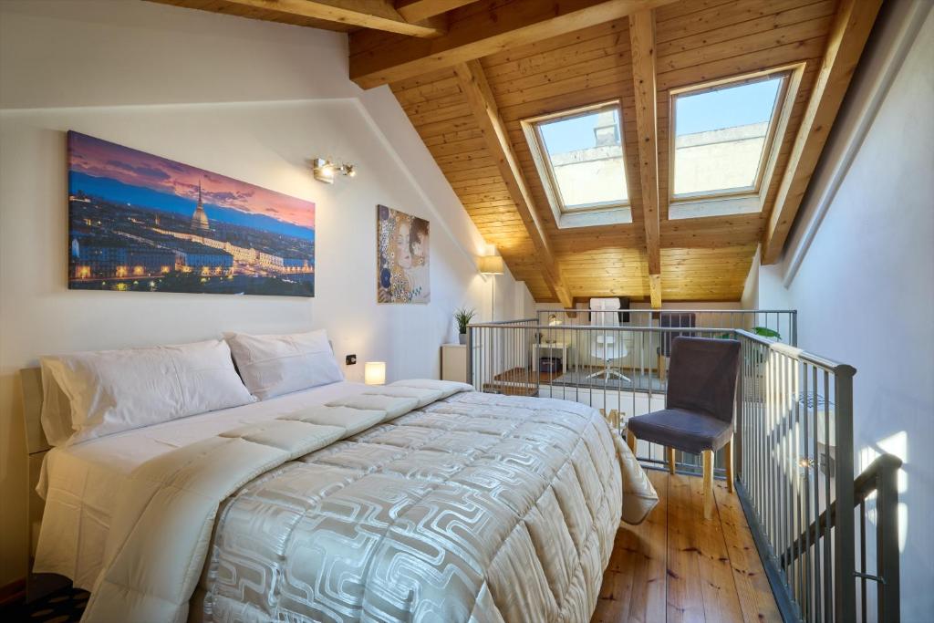 una camera da letto con un letto grande e una sedia di Elegante Loft vicino Piazza Vittorio a Torino