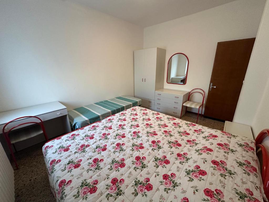 ein Schlafzimmer mit zwei Betten mit geblümter Tagesdecke in der Unterkunft Appartamento 3 camere con vista mare - Agenzia Cocal in Caorle