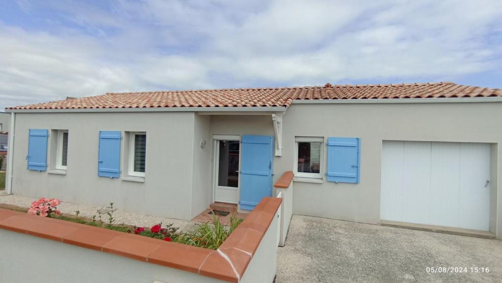 Maison blanche avec volets bleus dans l'établissement Grande maison 100m2 7 personnes 3 chambres, à Bretignolles-sur-Mer
