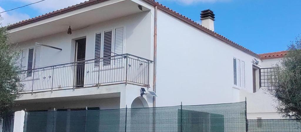 a white house with a fence in front of it at Casa relax Berchida in Capo Comino