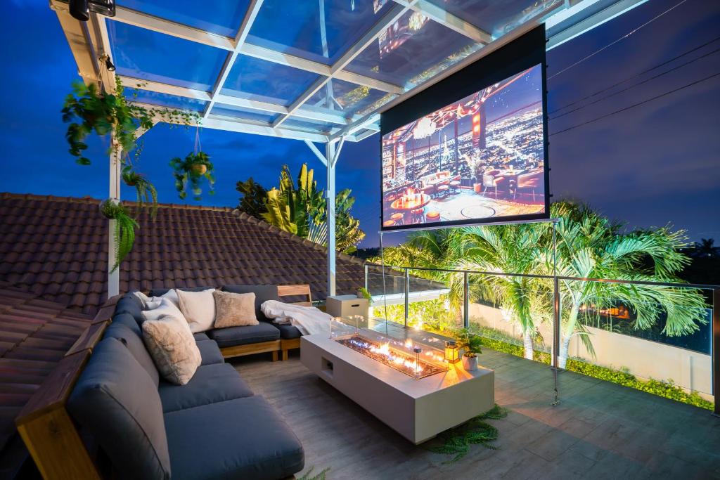 a living room with a couch and a large screen at Kira Japandi Escape with Sauna & Rooftop cinema in Hua Hin