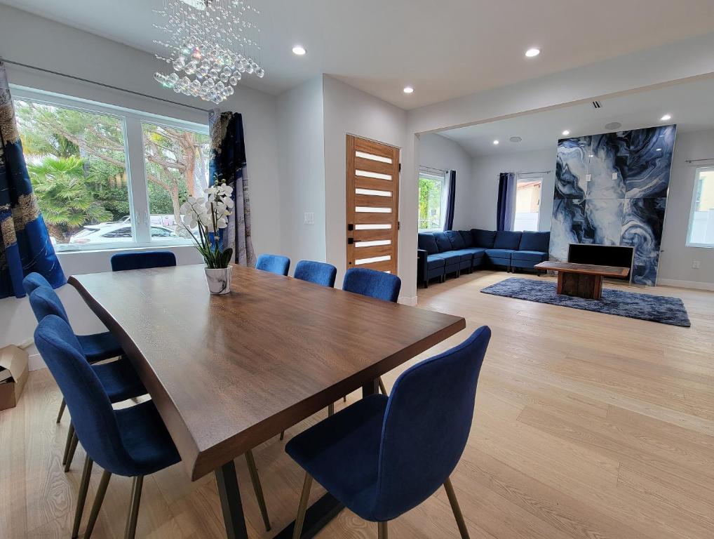 ein Esszimmer mit einem Holztisch und blauen Stühlen in der Unterkunft Modern luxury 3 bedroom home next to La Cienega Plaza with parking, WiFi, TV, BBQ 10 minutes to Rodeo Drive in Los Angeles