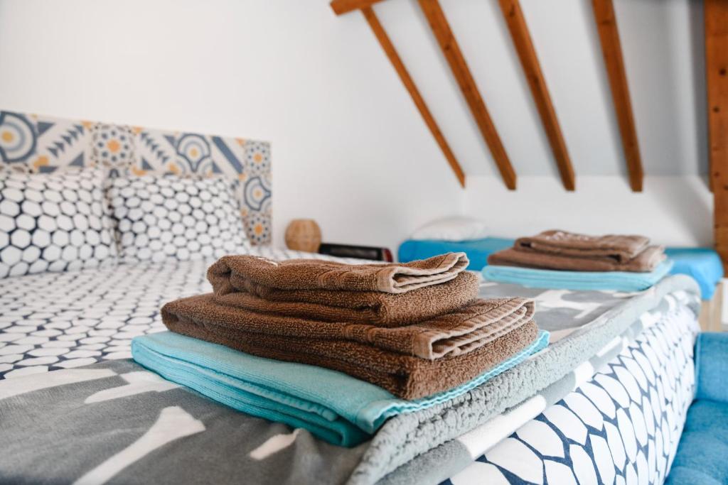een stapel handdoeken bovenop een bed bij GO4SURF beach Lofts in Peniche