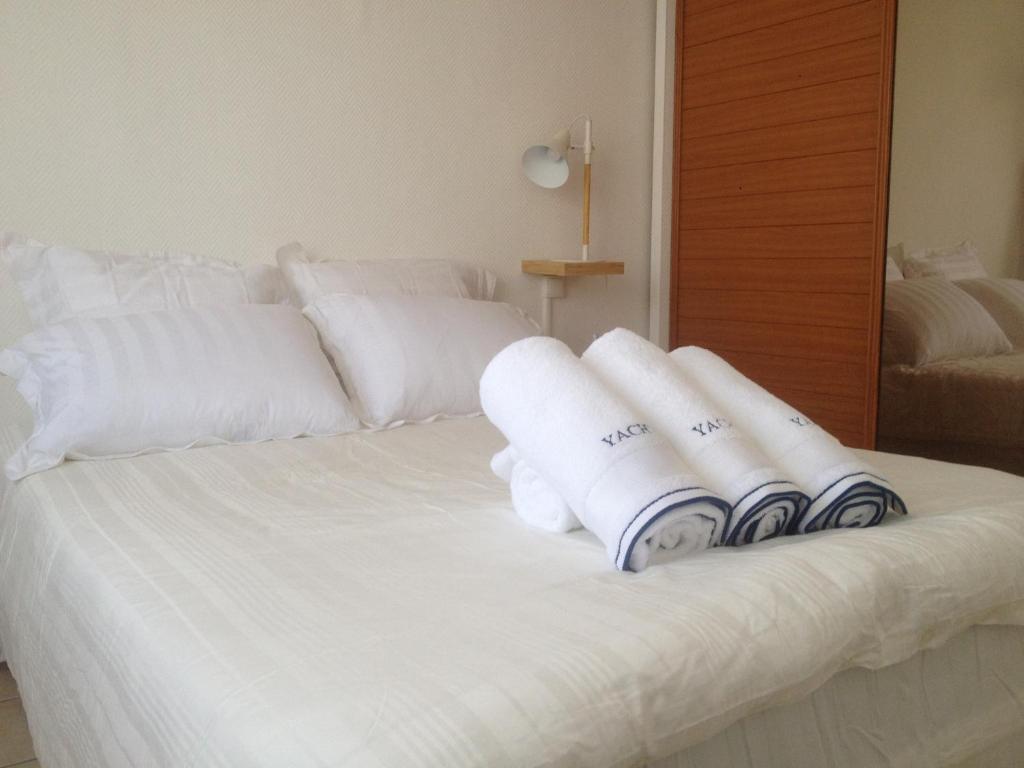 - un lit blanc avec des serviettes de toilette dans l'établissement Plage Parc Parking, à La Rochelle