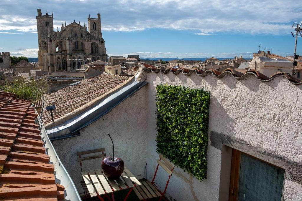 un bâtiment avec une haie verte en haut dans l'établissement Cœur d 'amande, à Narbonne
