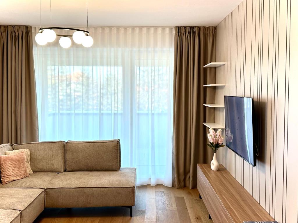 a living room with a couch and a large window at 4FriendsBrasov K34 in Braşov