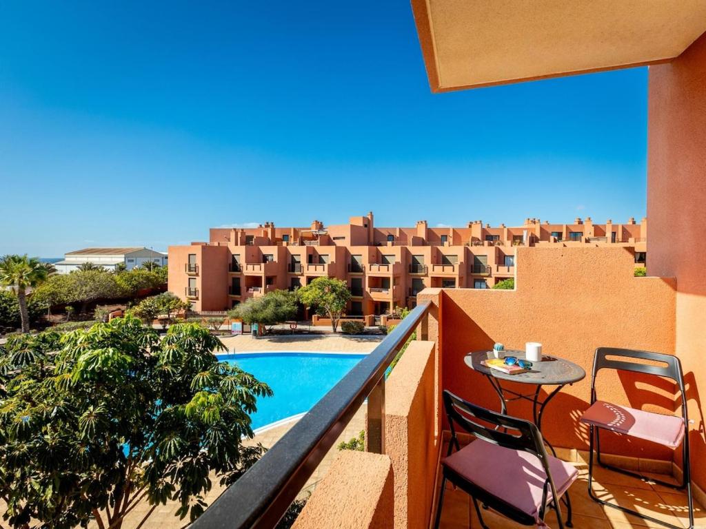 a balcony with a pool and a table and chairs at Sea breeze Sotavento III in La Tejita