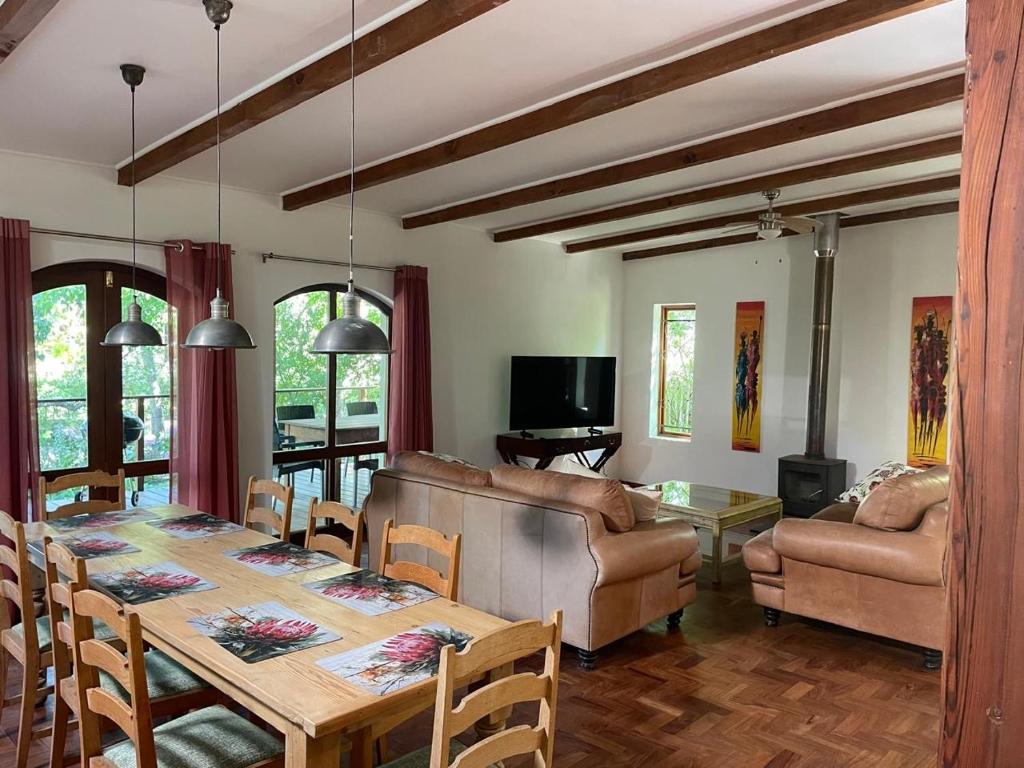 a dining room with a table and a living room at This Is Us in Franschhoek