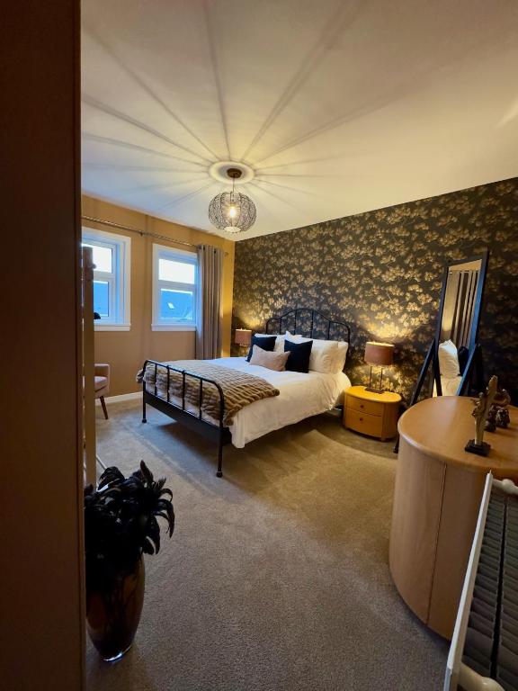 a bedroom with a bed and a table in a room at Cochrane House in Stirling