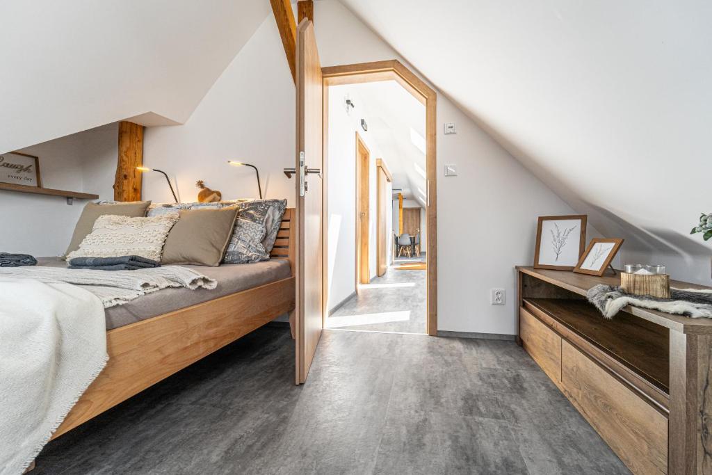 a bedroom with a large bed and a hallway at Podkrovní apartmán Studnice in Nové Město na Moravě