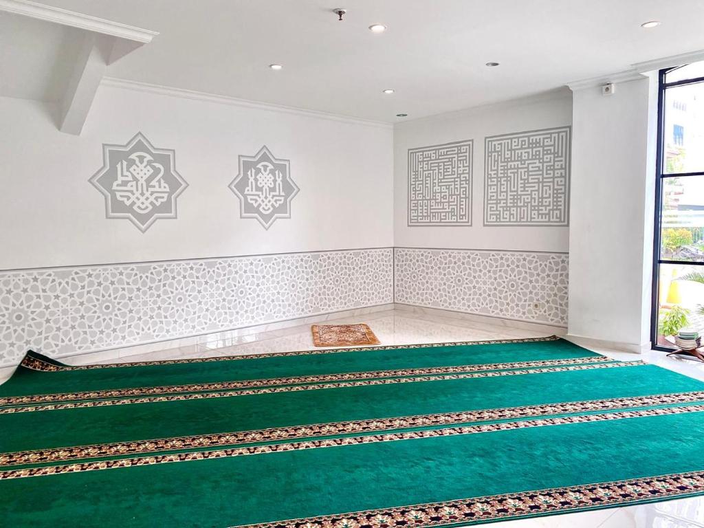 Postel nebo postele na pokoji v ubytování Dafam Enkadeli Thamrin Jakarta Syariah