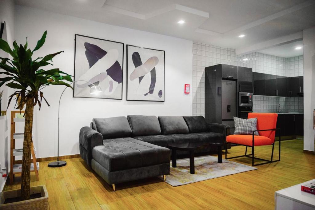 a living room with a black couch and a red chair at Shortlet spaces in Lekki