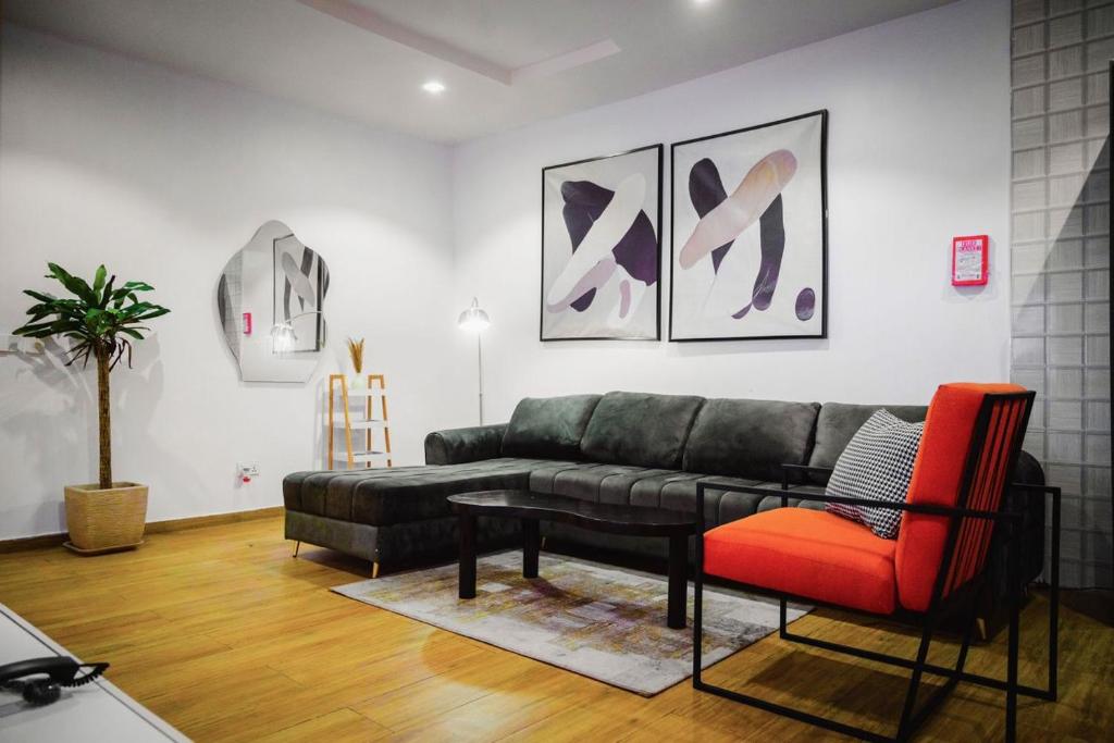 a living room with a black couch and a red chair at Shortlet spaces in Lekki