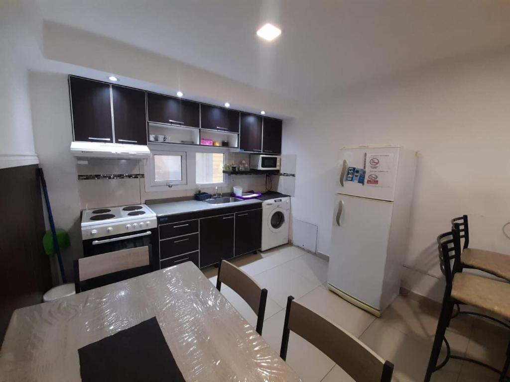 a kitchen with a table and a white refrigerator at Morada del sur in Ushuaia