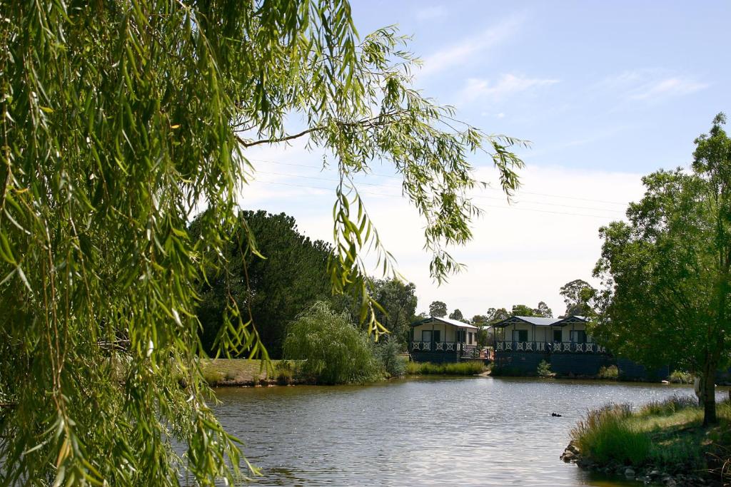 uma vista para um rio com casas e árvores em Capital Country Holiday Park em Camberra