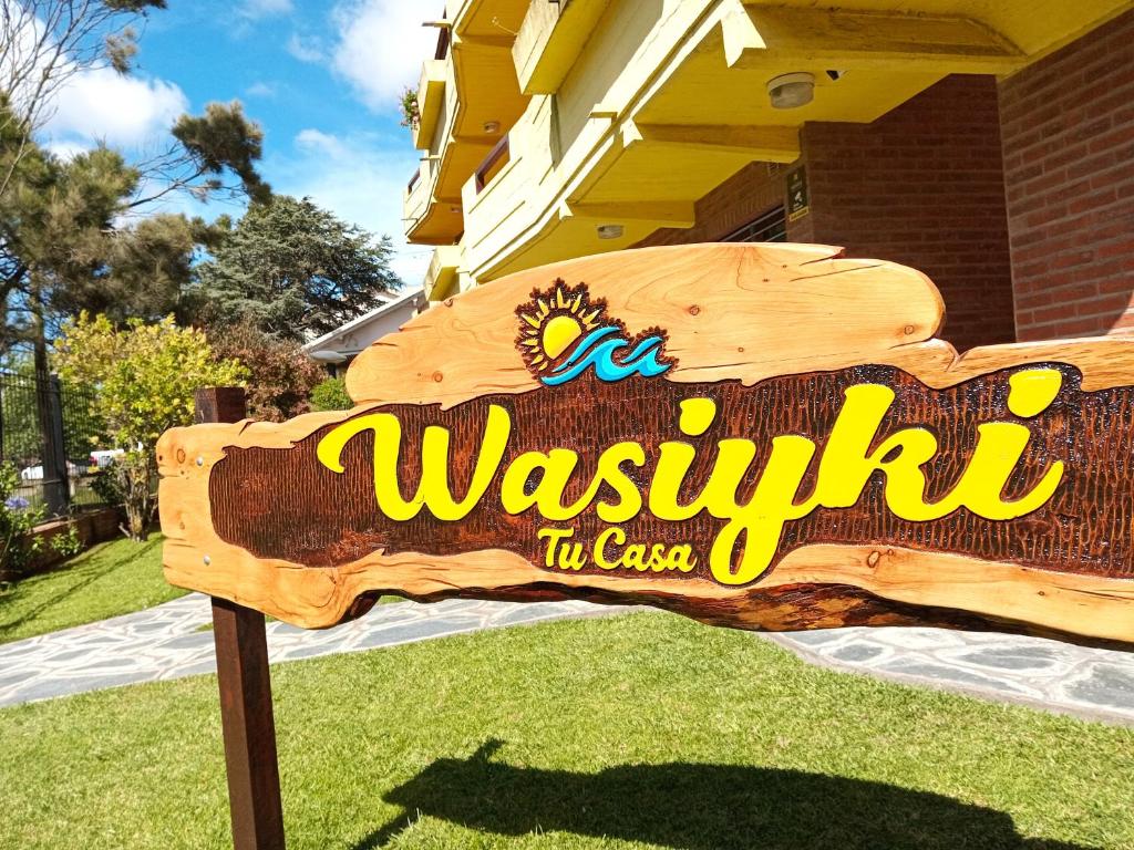 a sign in the grass in front of a house at Complejo de Mar Wasiyki - Villa Gesell in Villa Gesell